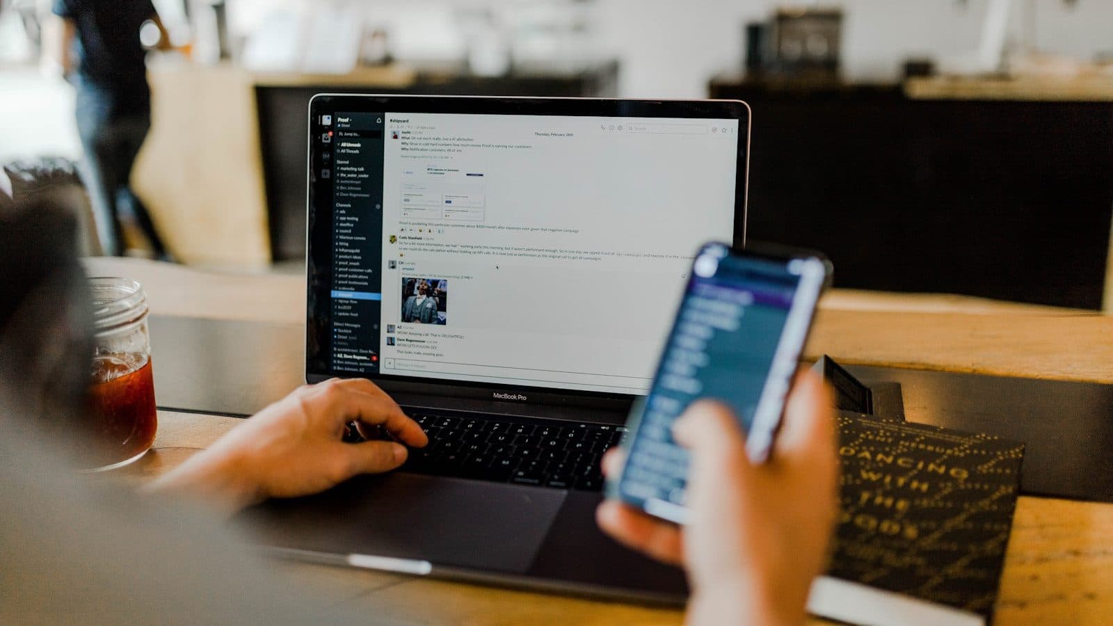 A visitor checking a business on their phone while a laptop sits open beside them — the mobile experience is the actual experience for most of your traffic