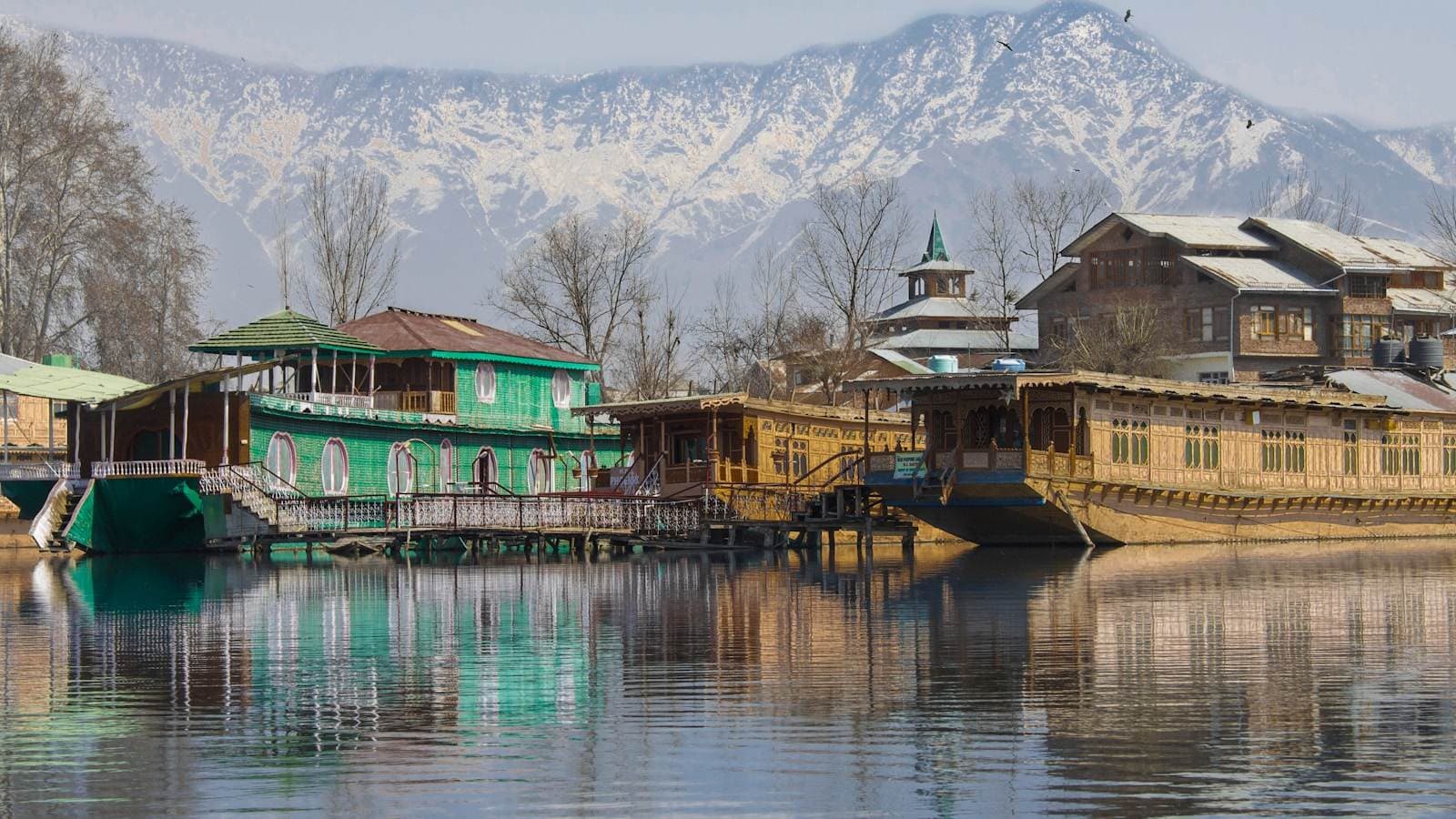 Dal Lake houseboats below the mountains — the valley's business seasons, connectivity and buying habits all shape what a website here has to do