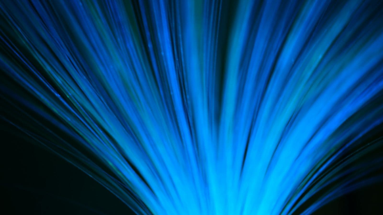 Hundreds of blue fibre optic strands fanning outwards from a single point and glowing at their tips, much like a CDN spreading copies of one website out to servers all over the world