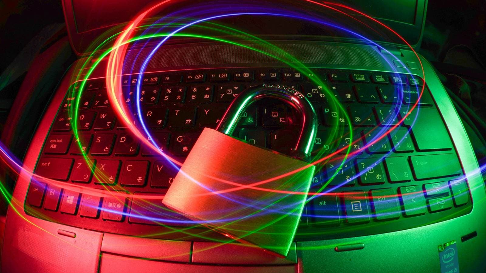 A padlock resting on a laptop keyboard, wrapped in swirling trails of red, green and blue light. Because every request passes through it first, a CDN has also become a website's first line of defence