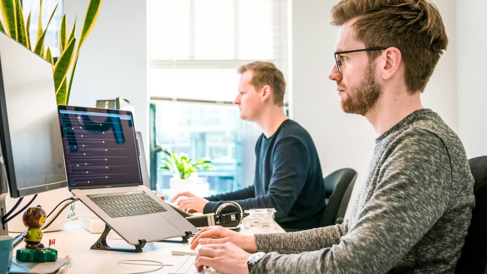 Two developers working through a build together — the right platform decision comes from what the business needs to do, decided before any code is written