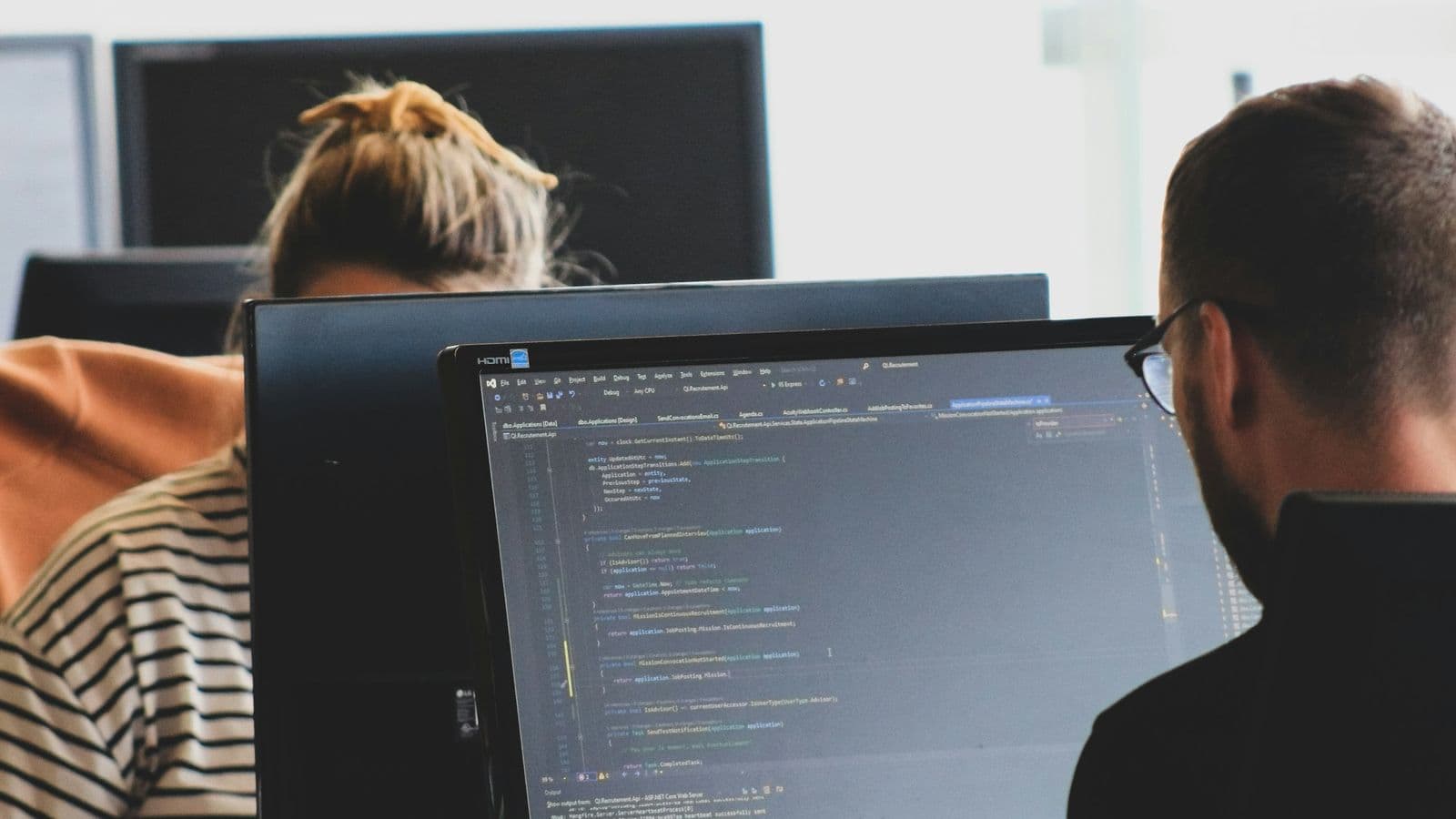 Engineers reviewing code together — money software is a craft discipline, and reviews are where most expensive mistakes are caught