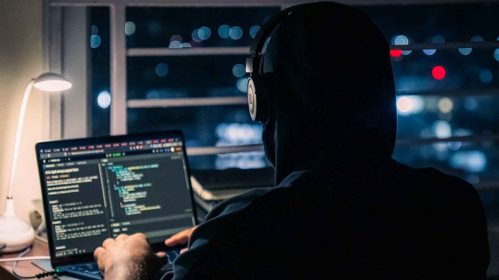 A developer working on a laptop late at night in a dark room, lit only by the screen. Steady, focused sessions on a project you care about do more for your profile than any streak