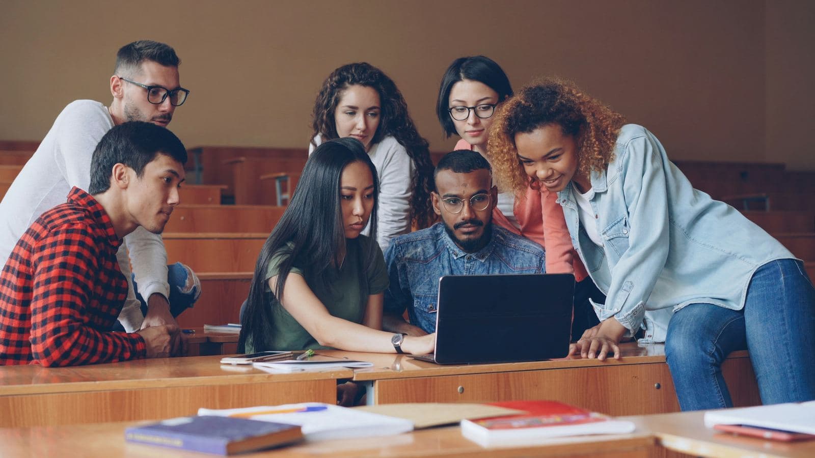 A group of university students gathered around a laptop in a lecture hall, laughing and pointing at the screen. A GitHub profile is often the first thing a classmate, senior or interviewer opens when they want to see what you've built