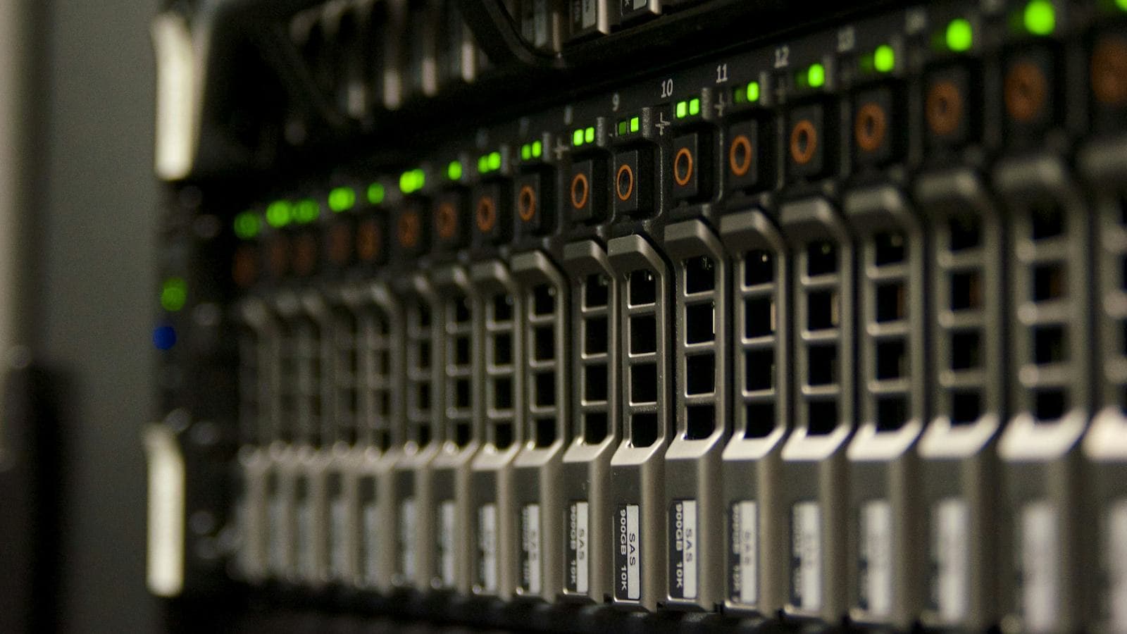 Close-up of a rack of blade servers with rows of drive bays and small green status lights glowing in the dark. Behind a load balancer, every one of these servers has to be interchangeable, holding nothing that the others don't also have access to