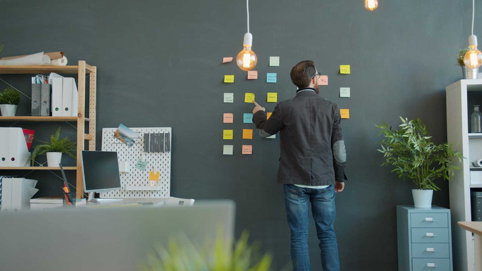 Someone arranging cards on a wall to plan a sequence of work — migrations succeed or fail on ordering, not on technology