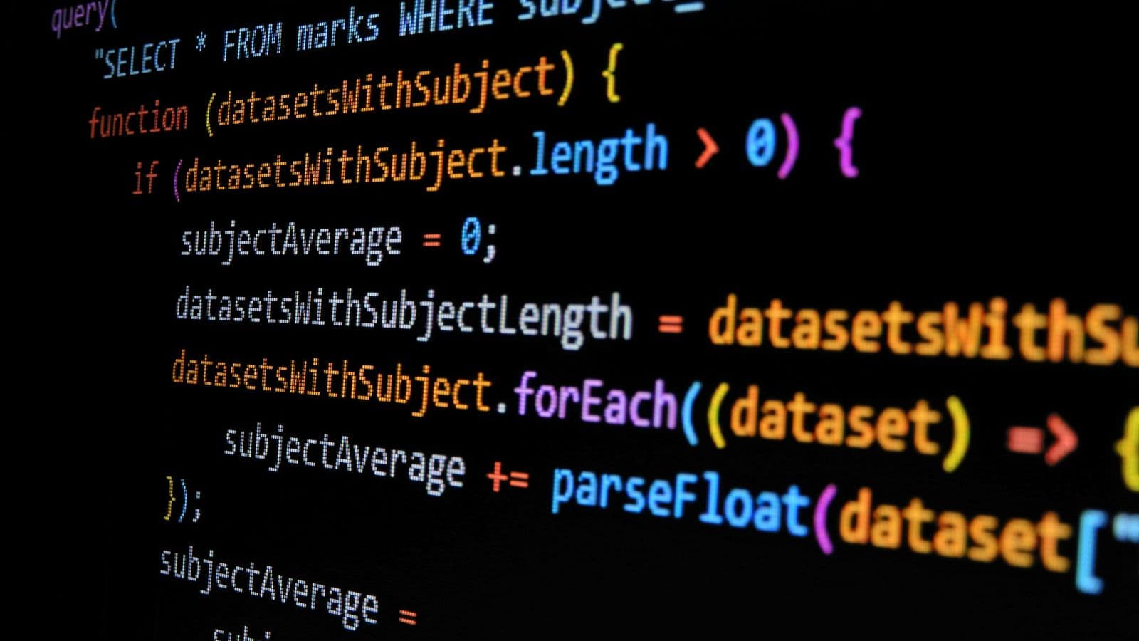 Lines of JavaScript code in bright syntax colours on a dark screen. Every line of script shipped to the browser has to be downloaded, parsed and run on the visitor's phone before the page responds properly