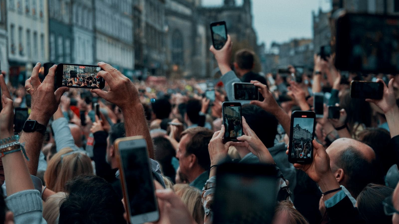 A crowd of people holding up their phones to film a procession. Every one of those phones holds an open connection that WhatsApp's servers have to keep alive