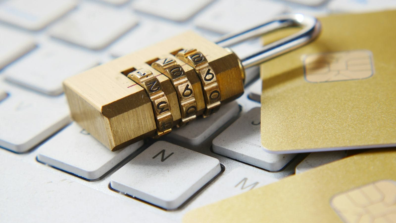 A brass combination padlock resting on a laptop keyboard. With end-to-end encryption, WhatsApp's servers route envelopes they cannot open