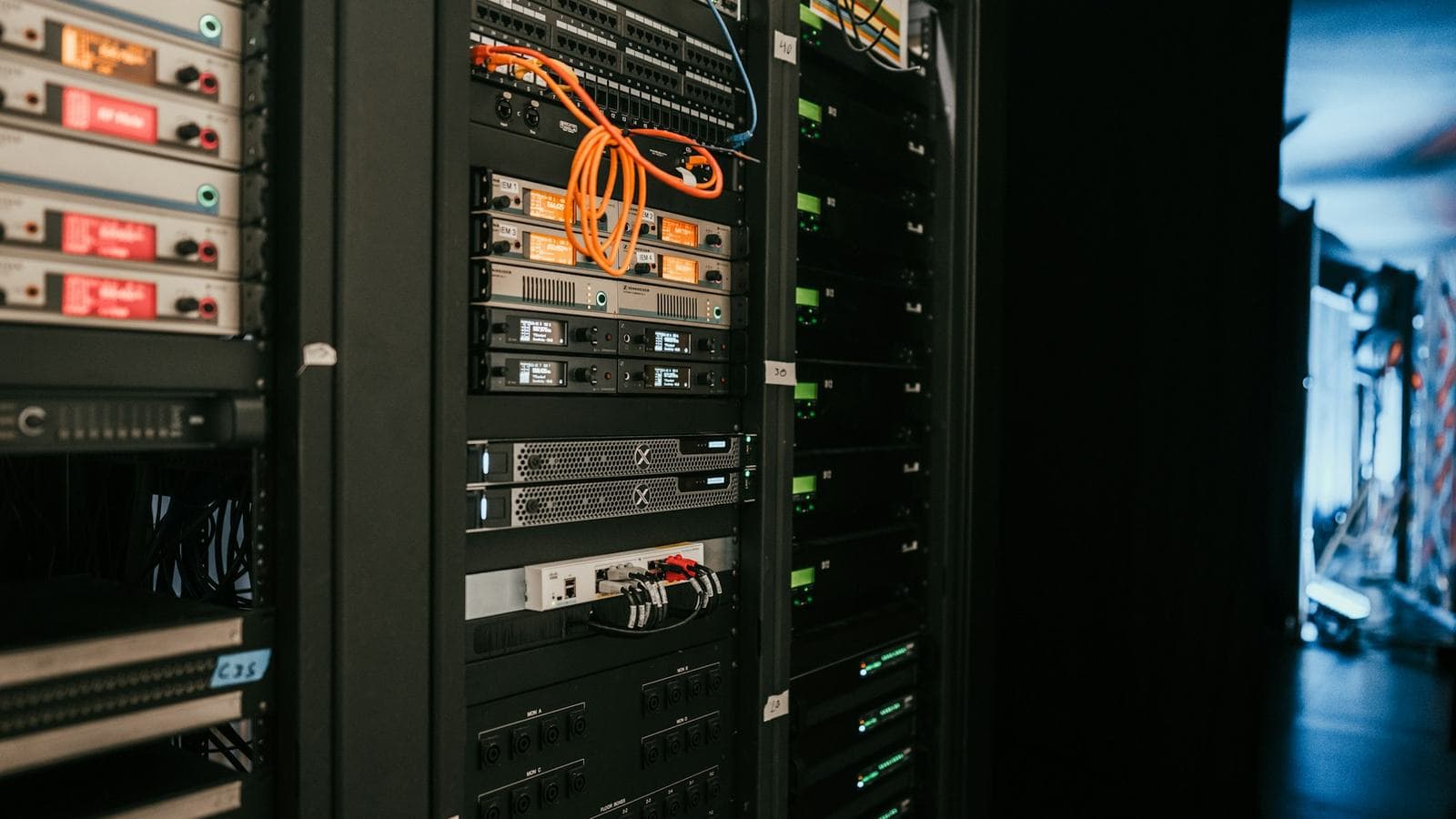 A rack of servers with orange network cables. WhatsApp's early approach was to make each machine hold millions of connections, rather than spreading the load over endless cheap boxes