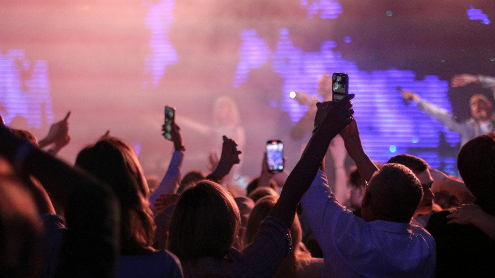 A concert crowd holding up glowing phones. Traffic spikes, like everyone messaging at midnight on New Year's Eve, are what a messaging system has to be designed for